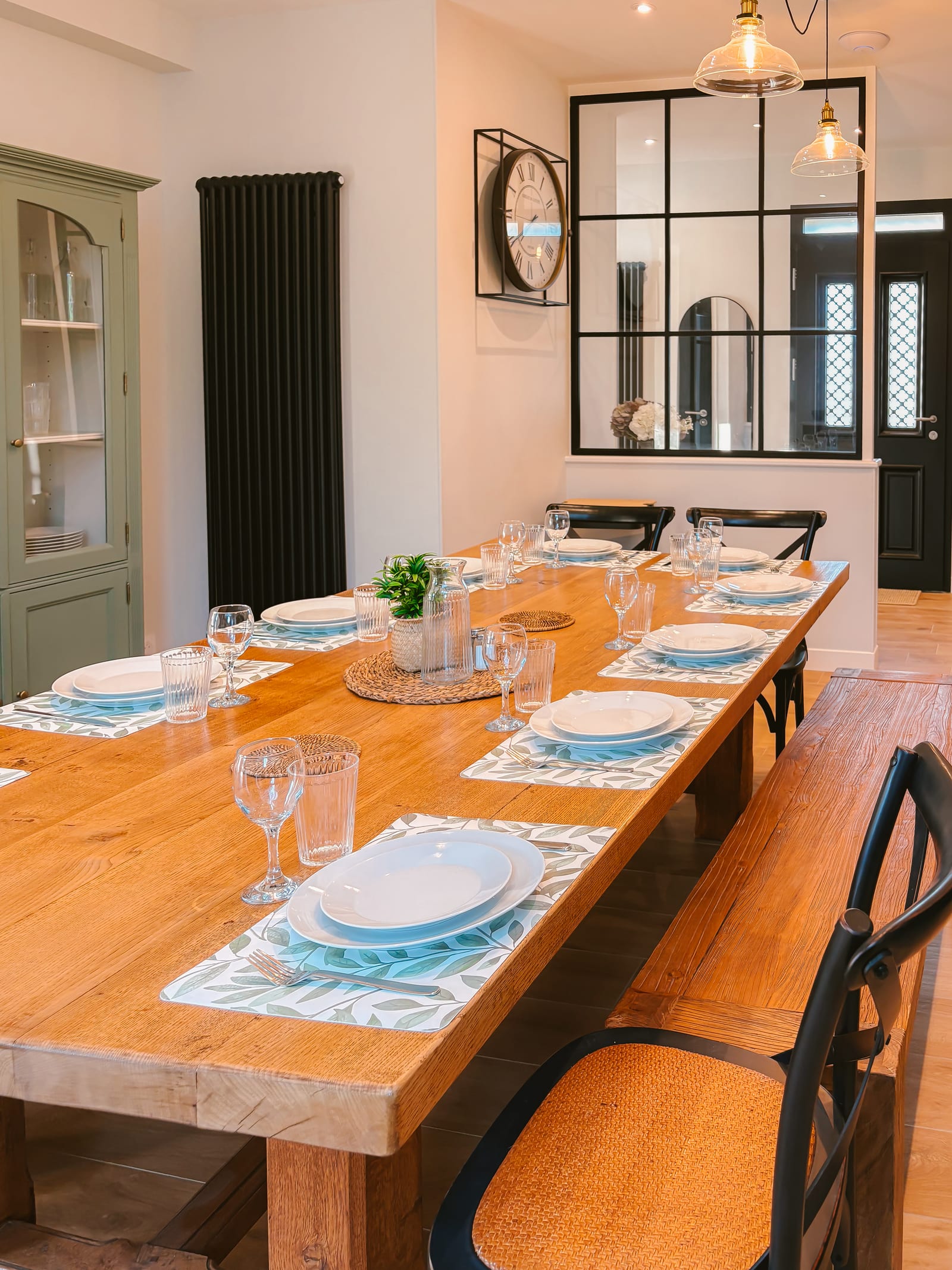 Longue table en chêne dressée pour le repas.