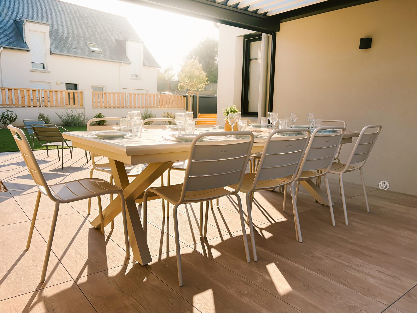 Grande table de la terrasse dressée pour dix sous la pergola.